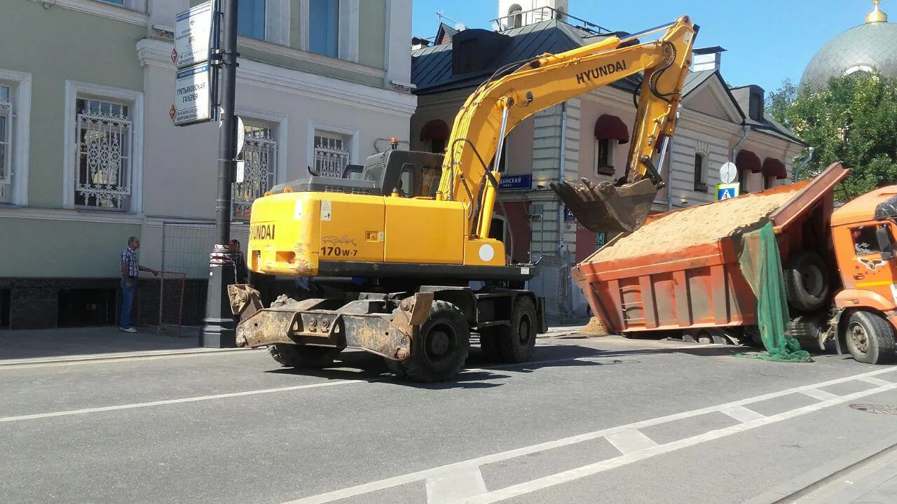 В Москве провалившийся под асфальт «КамАЗ» освобождают от песка и готовятся  вытаскивать | РИАМО