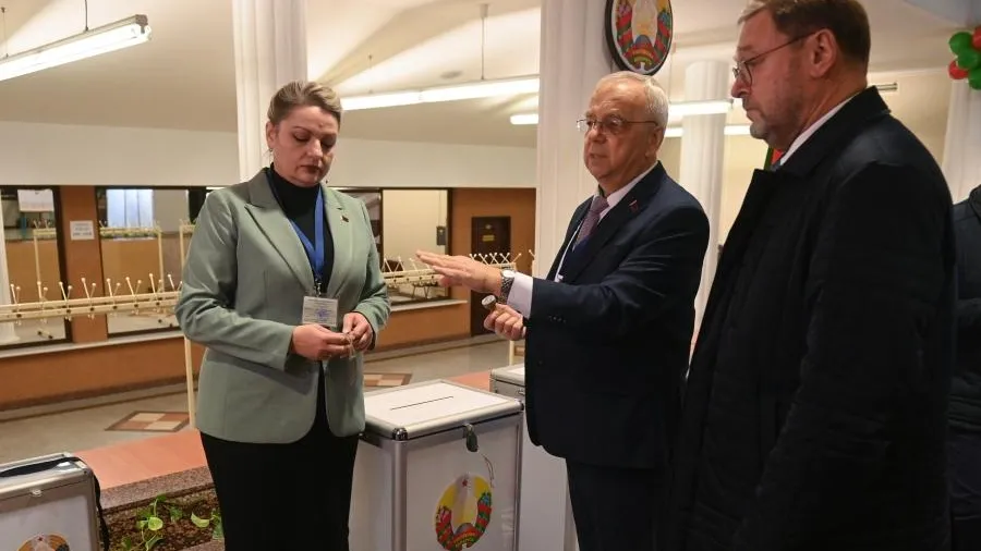 Координатор группы международных наблюдателей от Межпарламентской Ассамблеи СНГ, заместитель председателя Совета Федерации РФ Константин Косачев (справа) наблюдает за подготовкой к проведению голосования на выборах президента Белоруссии избирательного участка №70 в Минске.
