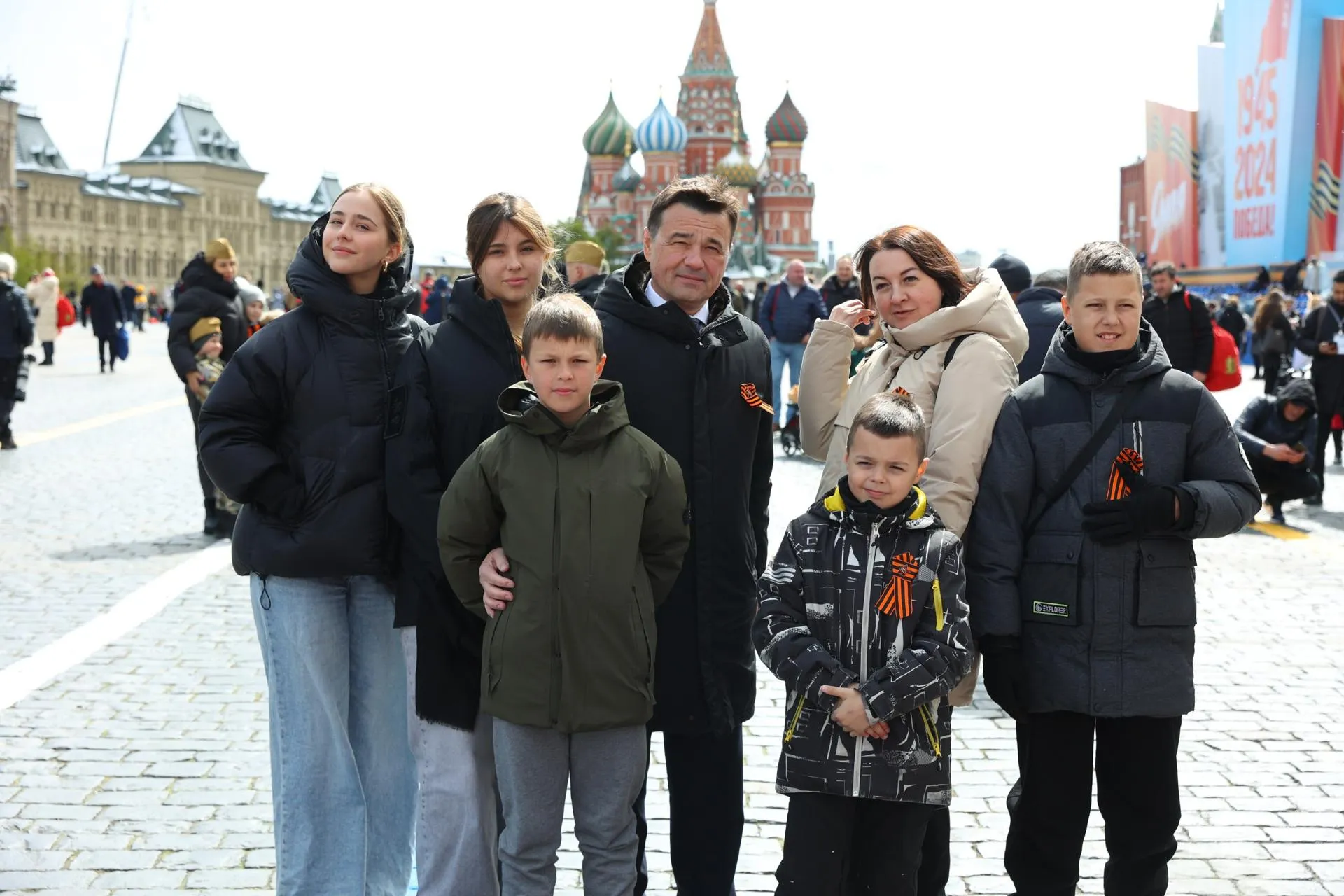 Семья погибшего участника СВО, Героя России Александра Сычева на параде Победы на Красной площади с Губернатором Московской области Андреем Воробьевым.